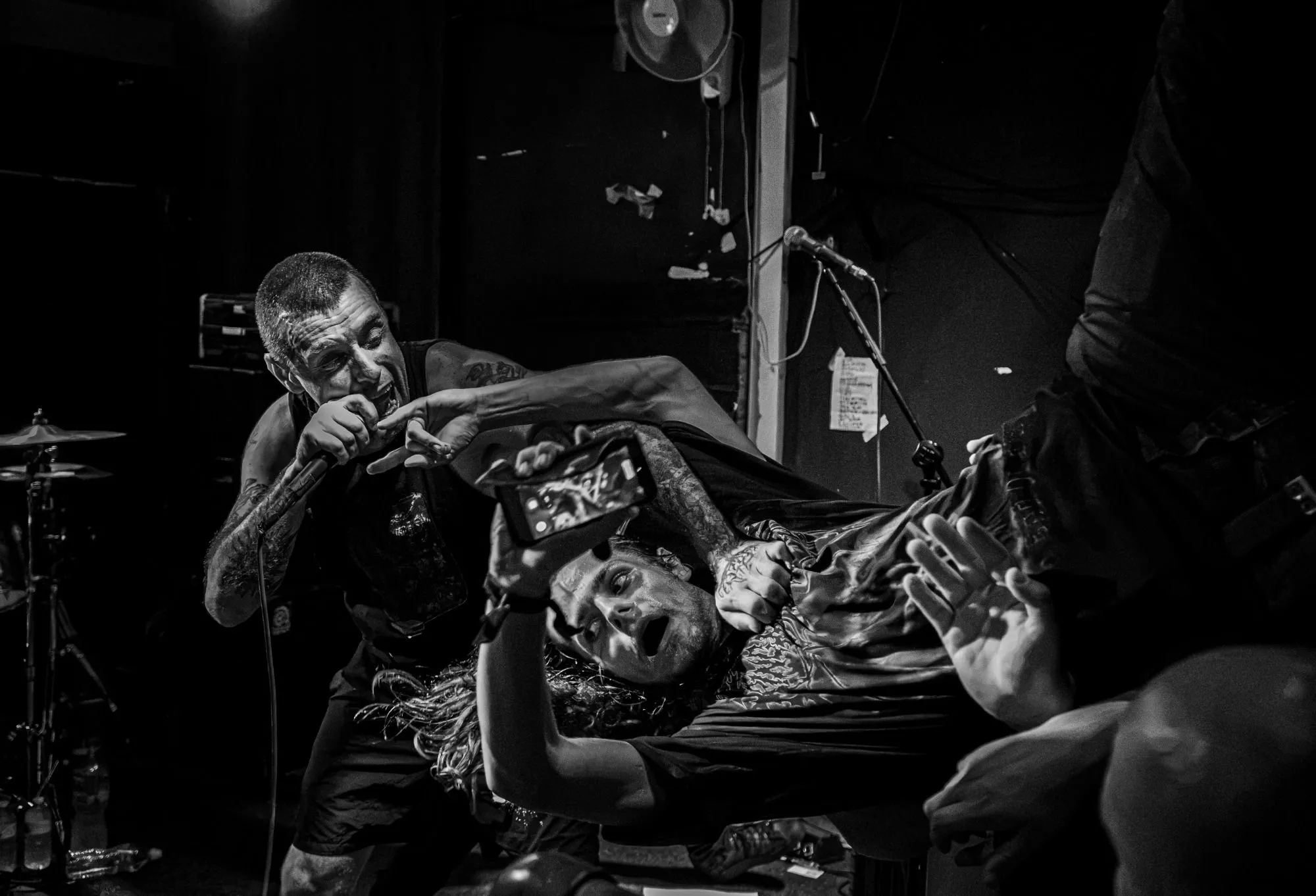 Two members of King Parrot on stage, one lying back across the other