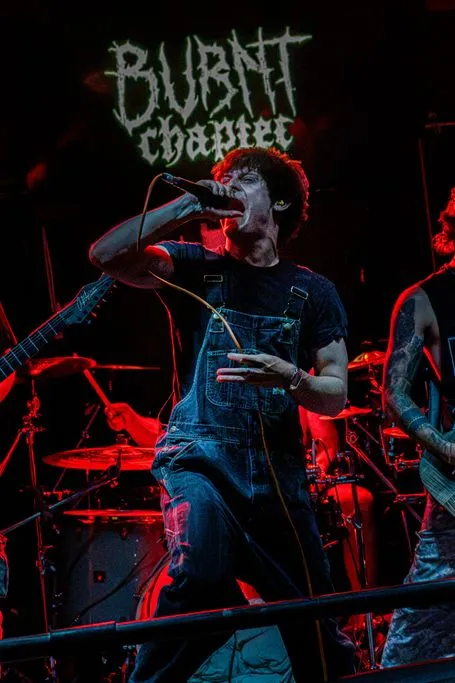 Burnt Chapter’s vocalist screaming in front of the band’s banner