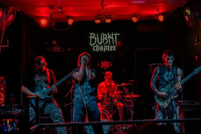 Burnt Chapter performing as a five-piece under red stage lights