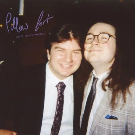 Single artwork for “Robots Versus Wrestlers”: two friends in suits posing for a flash photo
